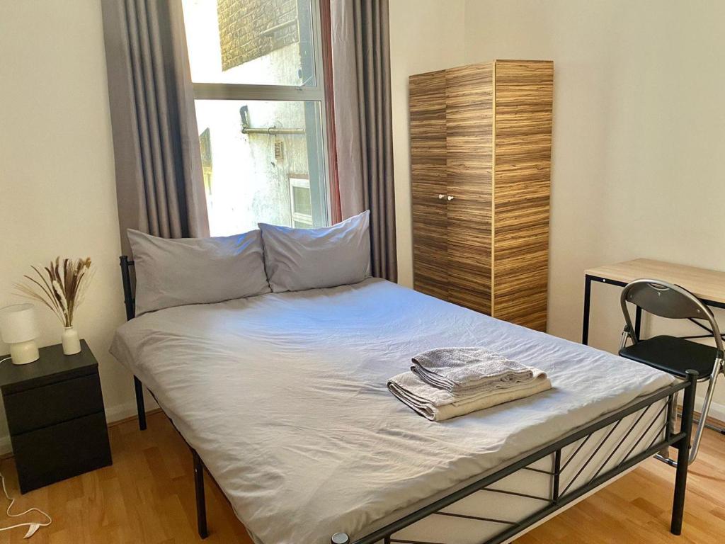 1 dormitorio con 1 cama con toallas en Double Room Near Central London, en Londres