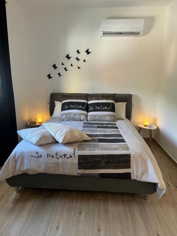 ein Schlafzimmer mit einem Bett mit vier Vögeln an der Wand in der Unterkunft RG MAISON in Morino