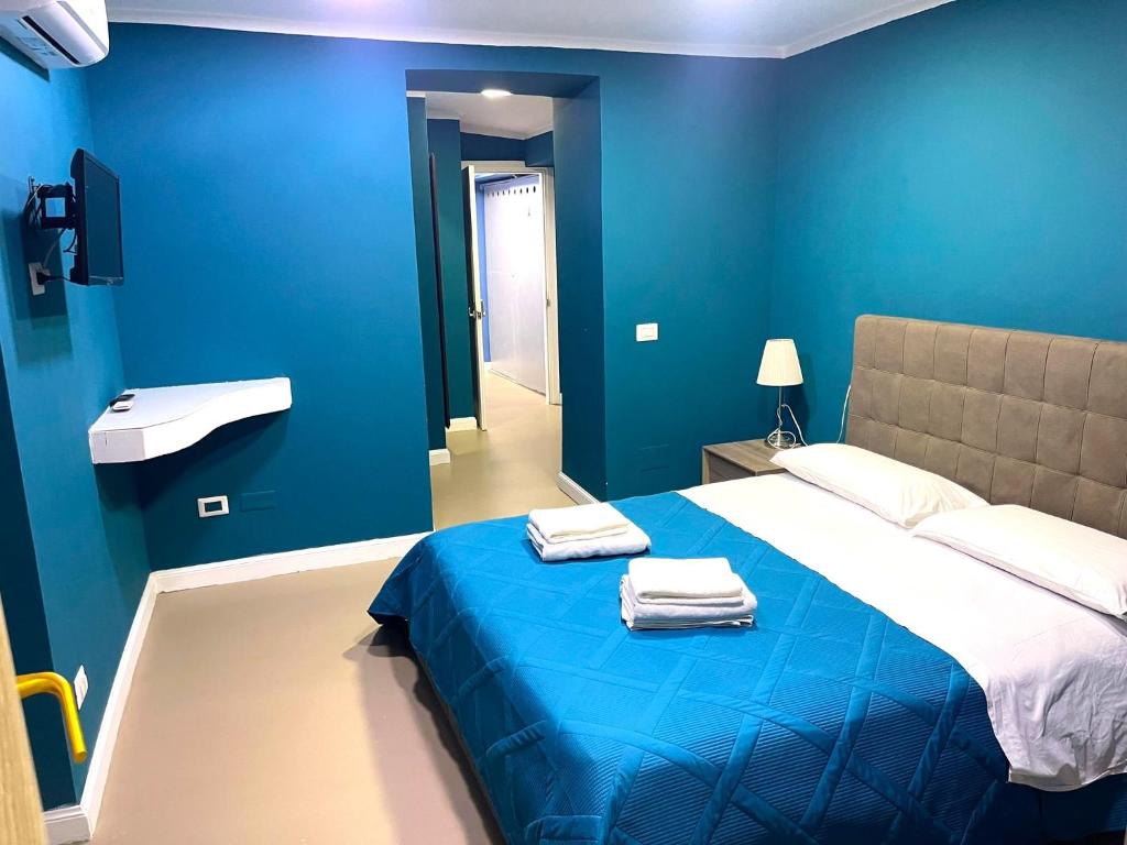 ein blaues Schlafzimmer mit einem Bett mit Handtüchern darauf in der Unterkunft Bed and Breakfast Napoli Centro storico in Neapel