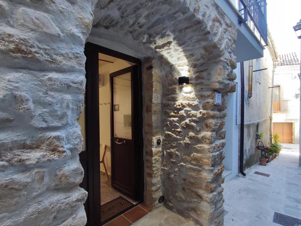 a doorway into a stone building with a black door at All'Arco Casa Vacanza in Acerenza