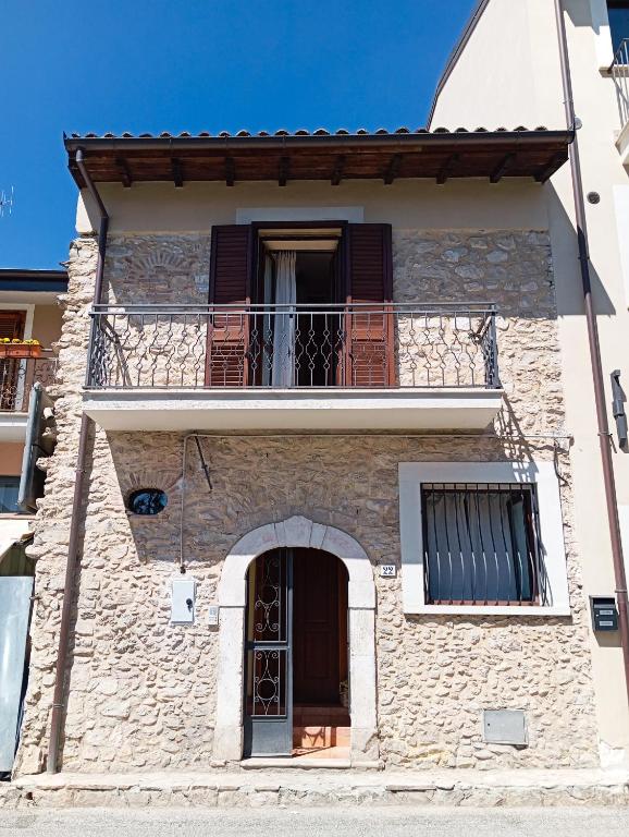 a building with a balcony and a window at La casa di B in Paganica