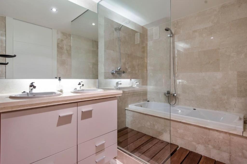 ソトグランデにあるCasa Algo luxe appartement met terras aan zee 133 m2のバスルーム(シンク2台、バスタブ、シャワー付)