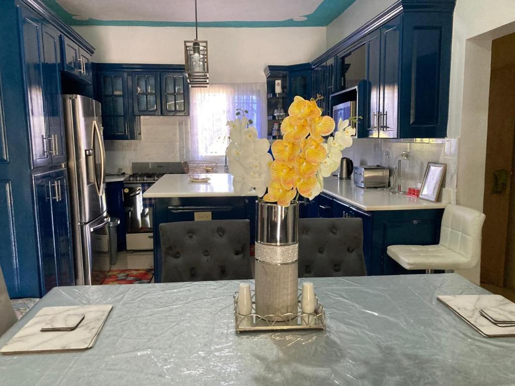 kuchnia ze stołem i wazą z żółtymi kwiatami w obiekcie Blissful Retreat in Gravel Hill 
