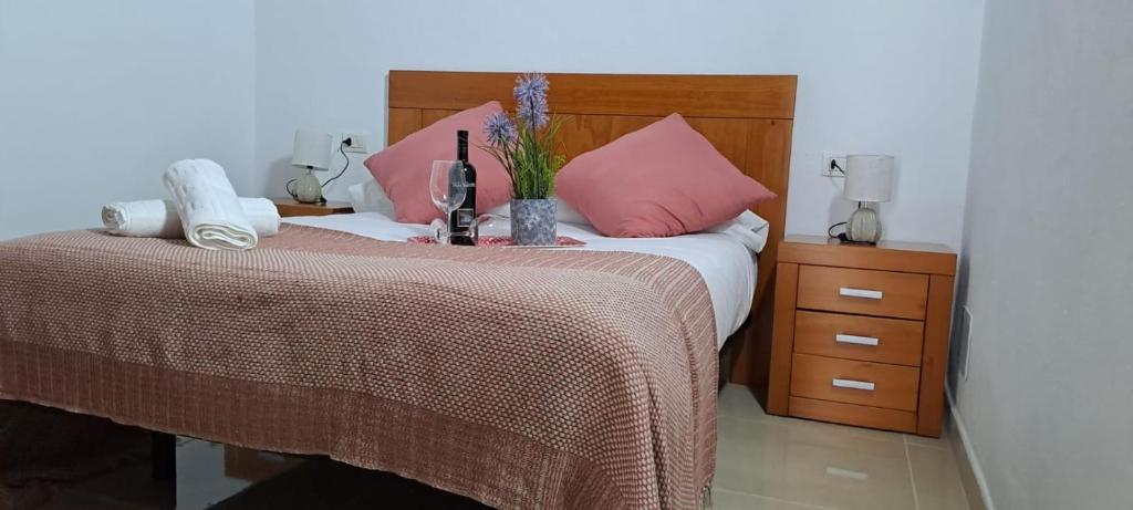 a bedroom with a bed with pink pillows at El Cachorro in San Miguel de Abona