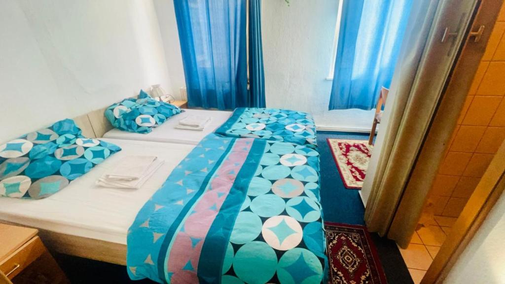 1 dormitorio con 1 cama con sábanas azules y blancas en Maccaroni Restaurants & Hotels en Meiningen