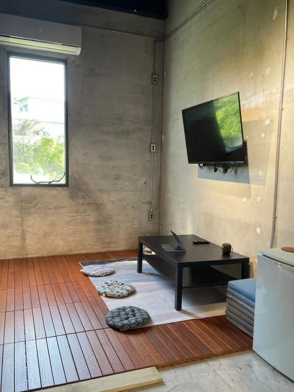 a living room with a table and a flat screen tv at COOLFREEDIVING Hostel in Green Island