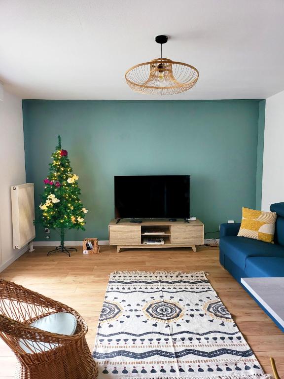 un salon avec un sapin de Noël et une télévision dans l'établissement Les couleurs de Poteries - avec garage gratuit, à Strasbourg