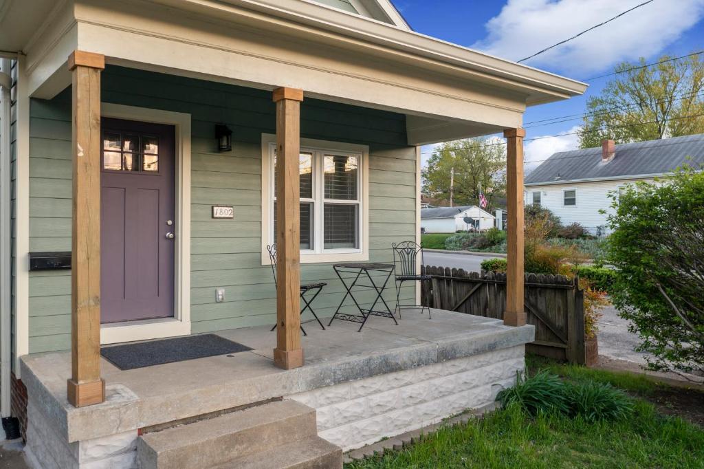 a front porch of a green house with a purple door at Highlands Home With Garage in Louisville