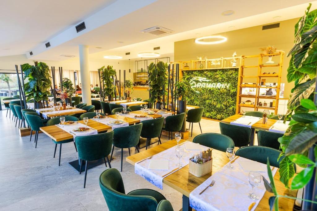 a restaurant with wooden tables and green chairs at Ranč Ramarin in Garčin