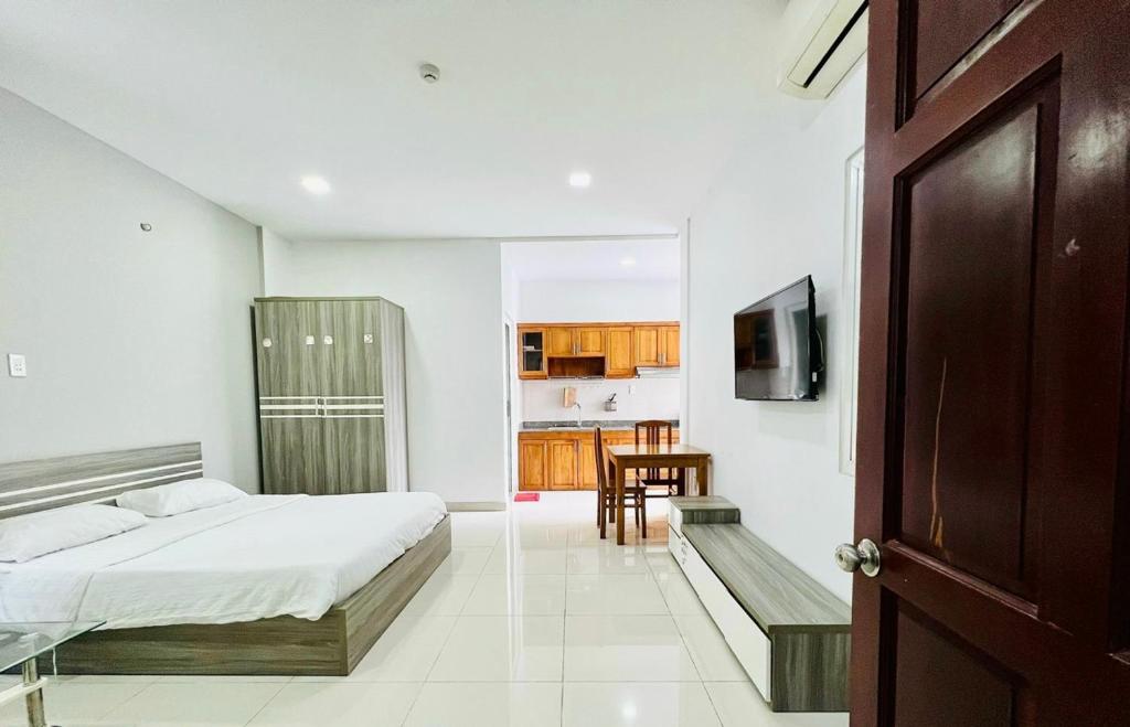 Cet appartement comprend une chambre avec un lit et une table ainsi qu'une cuisine. dans l'établissement EMERALD APARTMENTS, à Hô-Chi-Minh-Ville