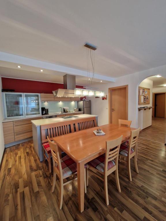 kuchnia i jadalnia z drewnianym stołem i krzesłami w obiekcie Apartment Lamtana w mieście Ischgl