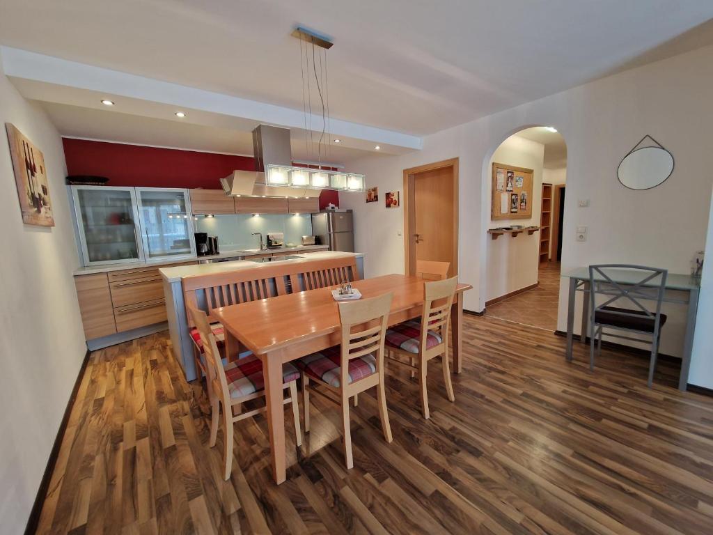 eine Küche und ein Esszimmer mit einem Holztisch und Stühlen in der Unterkunft Apartment Lamtana in Ischgl