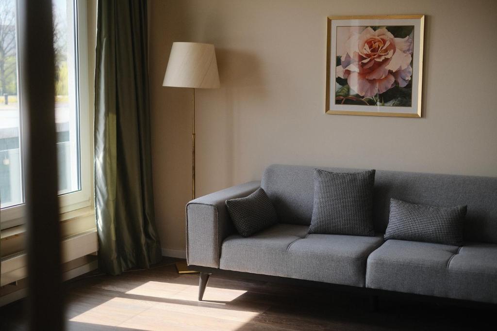 a living room with a couch and a window at PARKHOTEL - Rosarium in Uetersen