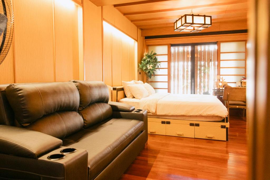 ein Wohnzimmer mit einem Sofa und einem Bett in der Unterkunft New York Loft & Japanese Magic by V4SKIN in Bangkok