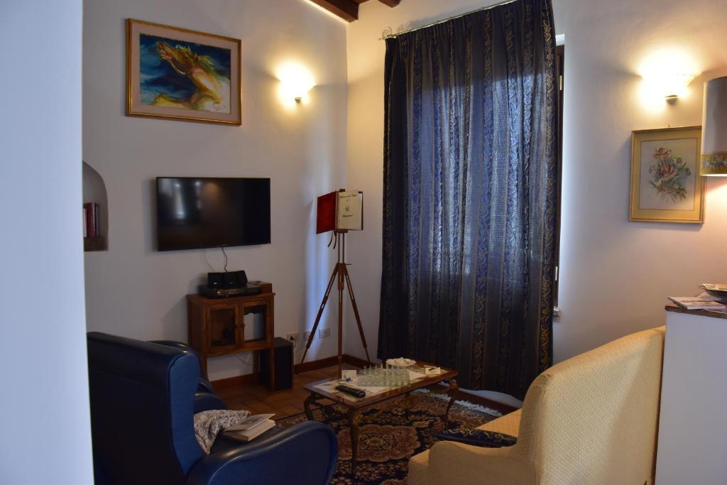 salon z 2 krzesłami i telewizorem w obiekcie Al Castello di Leprignano w mieście Capena