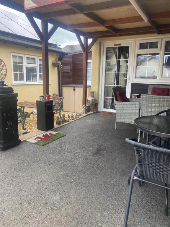 a covered patio with a table and chairs and a table at Private en-suite RUTHIN in Llanfair-Dyffryn-Clwyd
