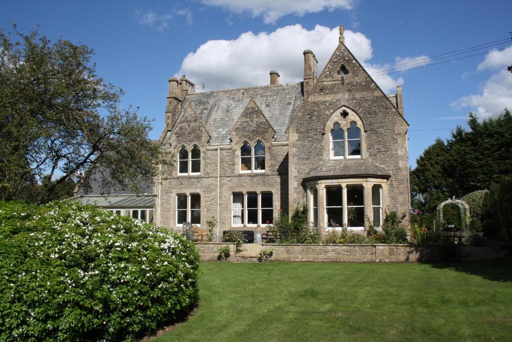 an old stone house with a green yard at The Rectory Lacock - Boutique Bed and Breakfast in Lacock