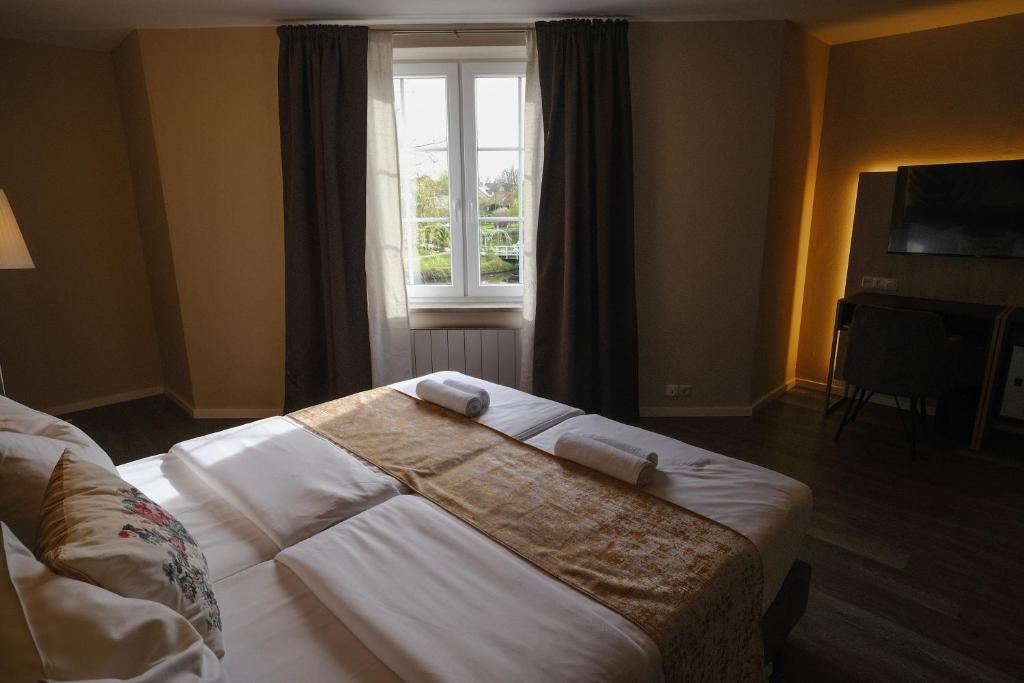 a bedroom with a large bed and a window at PARKHOTEL - Rosarium in Uetersen