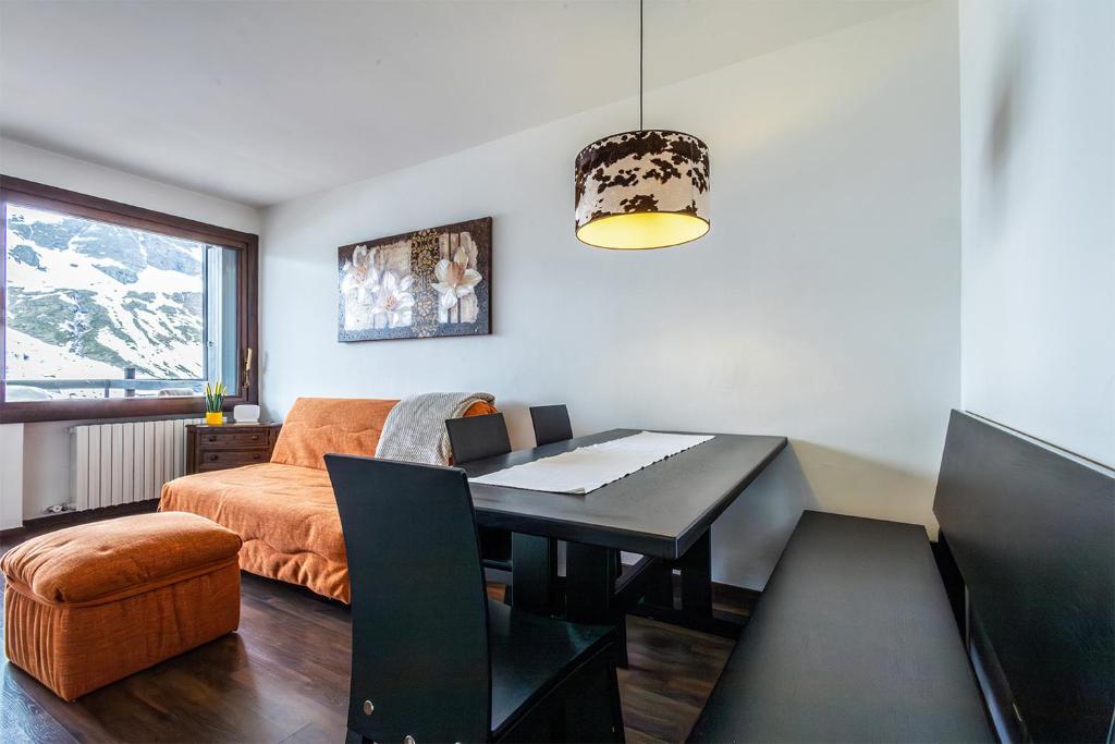 a living room with a table and a couch at Cervino View - 3 minuti a piedi dalle piste da scii - Parcheggio gratuito in Breuil-Cervinia