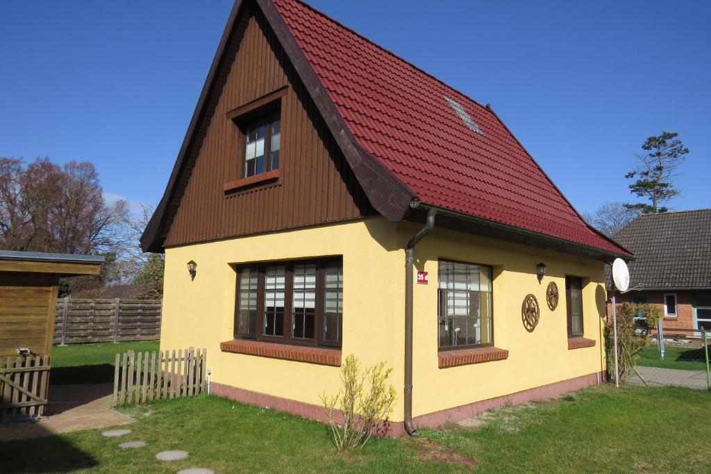 a yellow and brown house with a red roof at Ferienhaus Prerow in Prerow