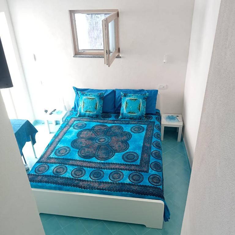 a bedroom with a bed with blue pillows at Domus Julia in Furore