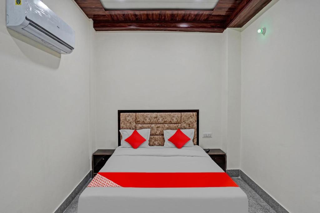 um quarto com uma cama com almofadas vermelhas em Flagship Shree Shyam Residency em Nova Deli