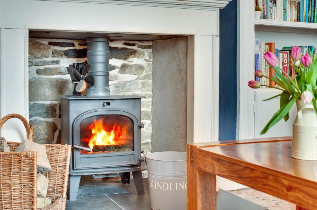 a wood stove in a living room with a table at Salvin House Alston in Alston