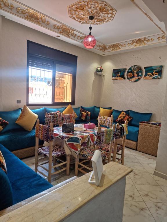 a living room with a blue couch and a table at Apprt Ennakhil 1 in El Jadida