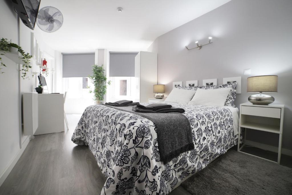 1 dormitorio con 1 cama con colcha en blanco y negro en Guest House Triunfo en Oporto