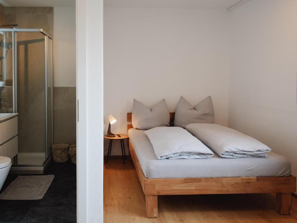 1 dormitorio con 1 cama con sábanas y almohadas blancas en Ehrenberg Apartments, en Reutte