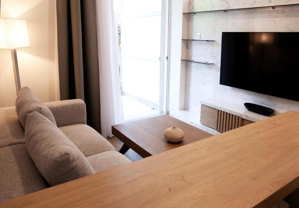 Una sala de estar con un sofá y un televisor. en Aelia Luxury Properties - Executive Apartment, en Atenas