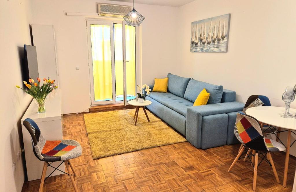 a living room with a blue couch and a table at Apartman Lopar Selce in Selce
