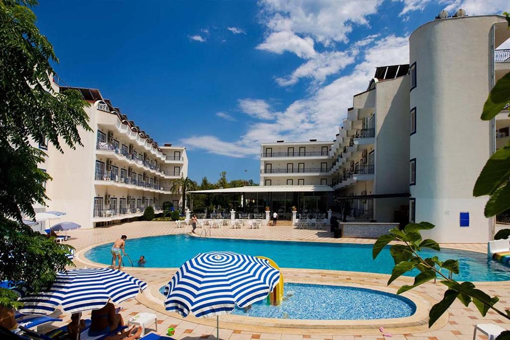 a swimming pool with two umbrellas in a resort at Ares Blue Hotel in Kemer