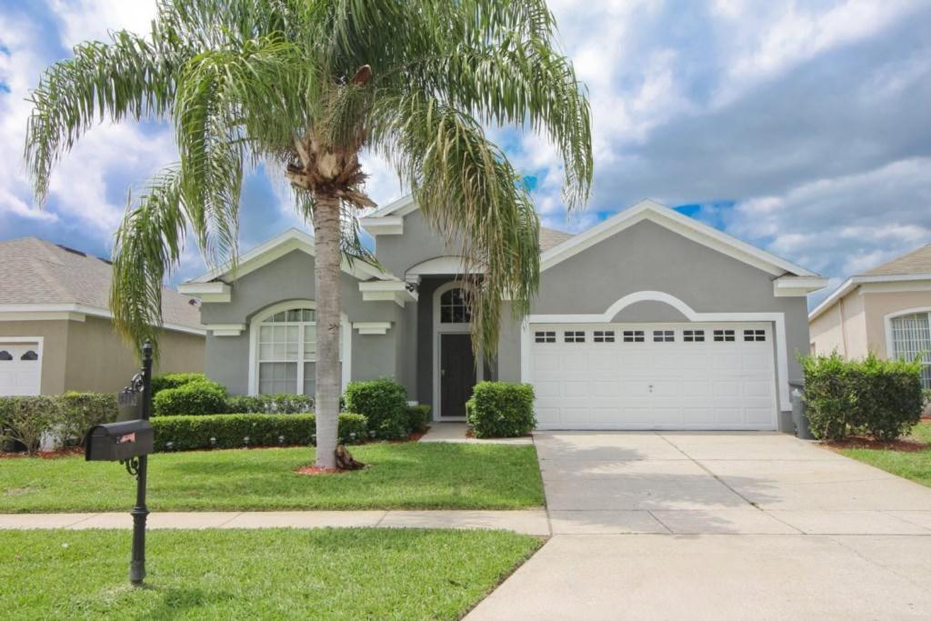 una palma di fronte a una casa di Luxury Villa Private Pool And Great Game Room a Kissimmee