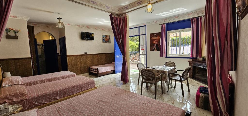 a bedroom with a bed and a table and chairs at Top Ourika in Aghbalou