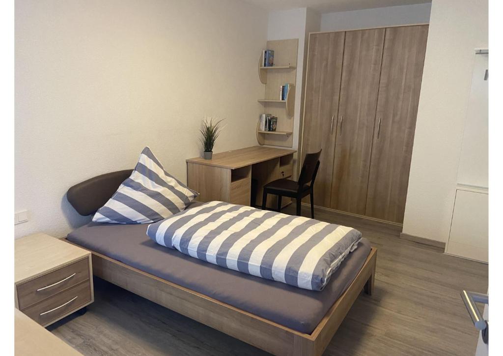 a bedroom with a bed with a desk and a chair at Apartment Stallberg in Eiterfeld