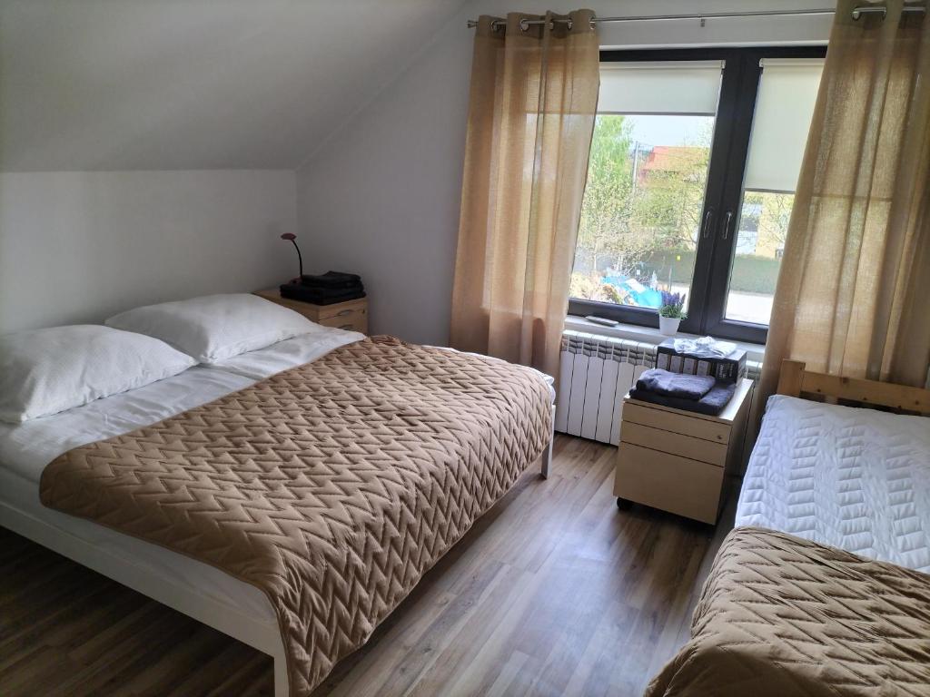 a bedroom with two beds and a window at Pensjonat u Joli in Sandomierz