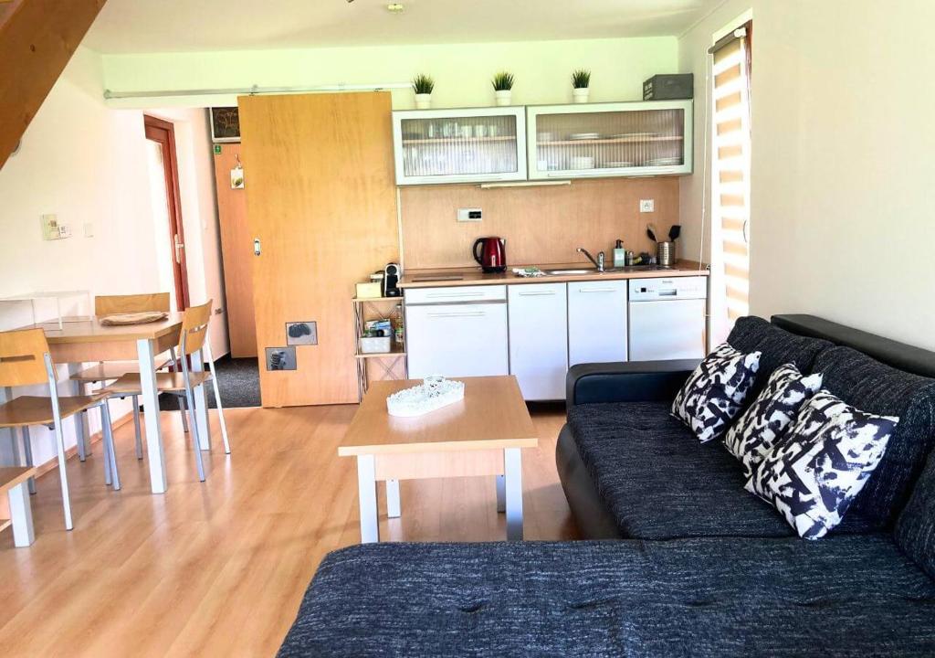 ein Wohnzimmer mit einem Sofa und einem Tisch sowie eine Küche in der Unterkunft Apartmán na Valašsku in Horní Bečva