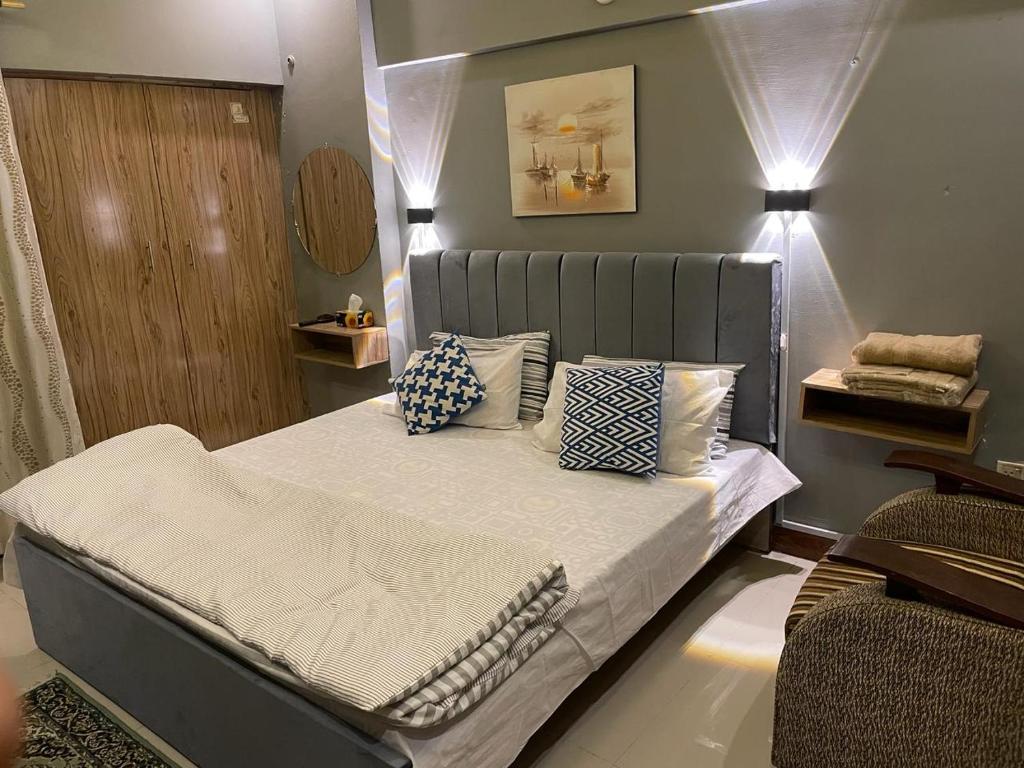 um quarto com uma cama com almofadas em Serene Private Room em Carachi