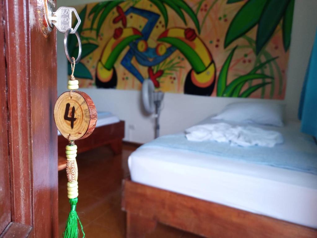 1 dormitorio con 1 cama y reloj en la puerta en MisMiriam, en Tortuguero