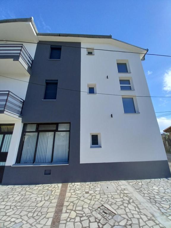 a white and black building with a cob at Ambient Apartments in Struga