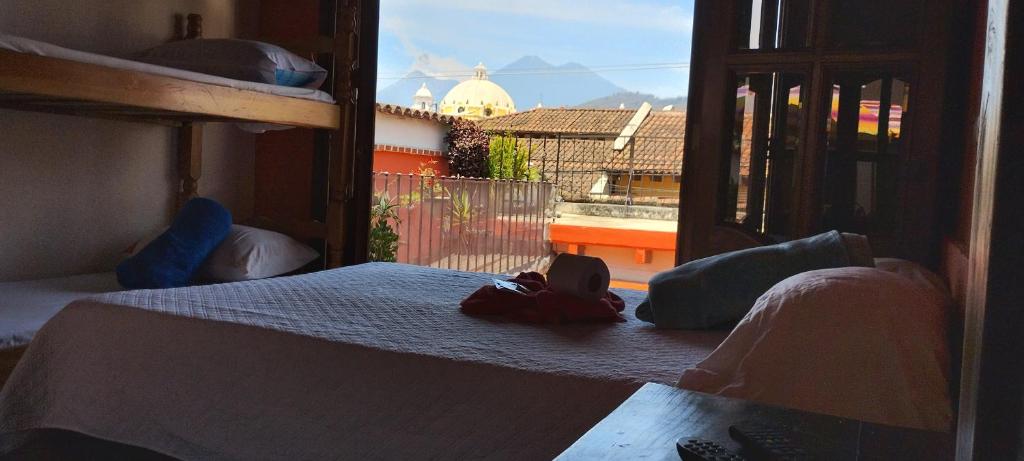 Hotel City of Dreams Antigua في أنتيغوا غواتيمالا: غرفة نوم بسرير وإطلالة على مبنى
