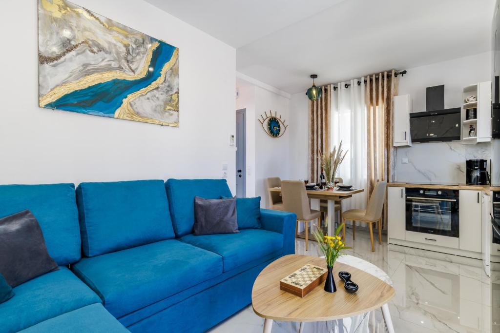 a living room with a blue couch and a table at Victoria House in Skopelos Town
