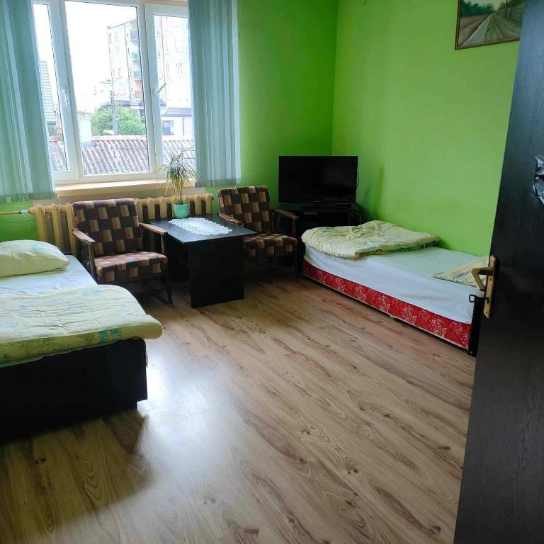 Pokój z 2 łóżkami, stołem i krzesłami w obiekcie Pokoje noclegowe w mieście Grajewo