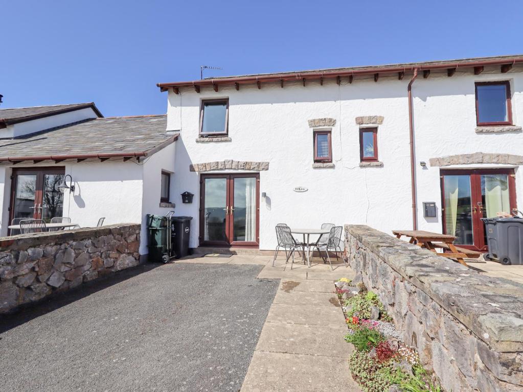 a white house with a stone wall and a patio at Hillview in Colwyn Bay