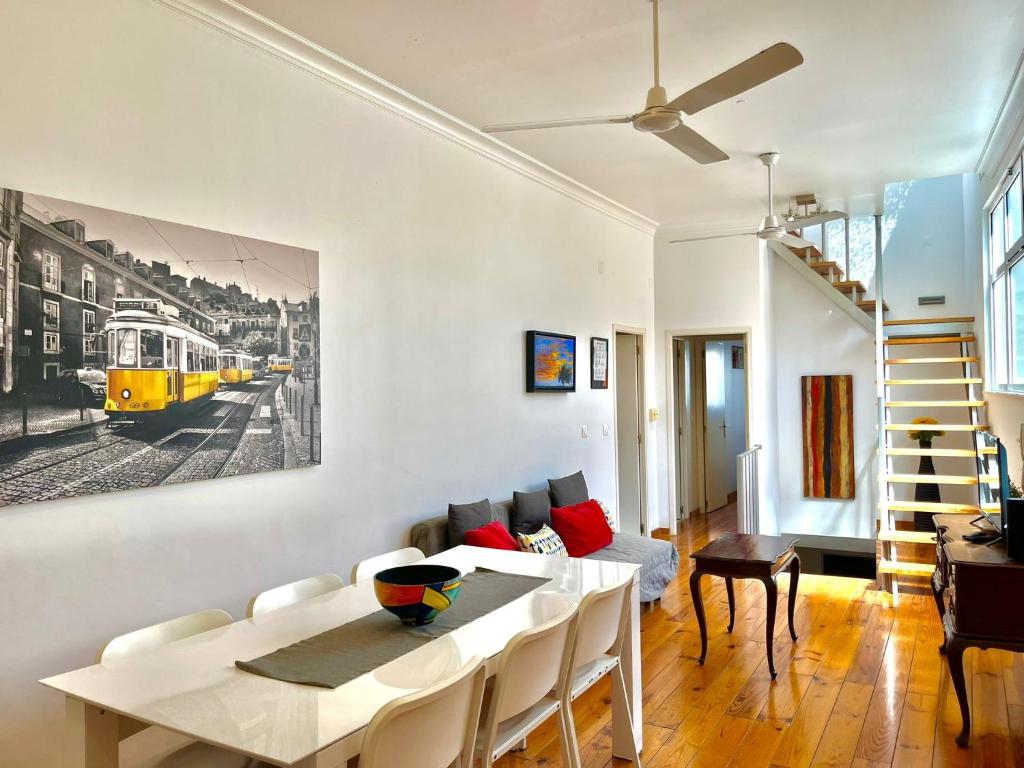 una sala de estar con una mesa y una pintura amarilla del tren en la pared en With Terrasse - 3 Bedroom, 3 Bathroom Triplex, en Lisboa