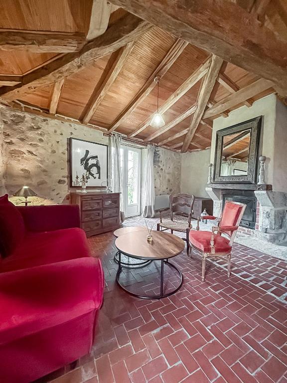 un salon avec un canapé rouge et une table dans l'établissement Le Clos des Écorcins - Terrasse - Parking privé, à Saint-Amand-sur-Sèvre