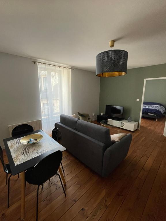 una sala de estar con un sofá y una mesa en Le Coeur de Rodez, en Rodez