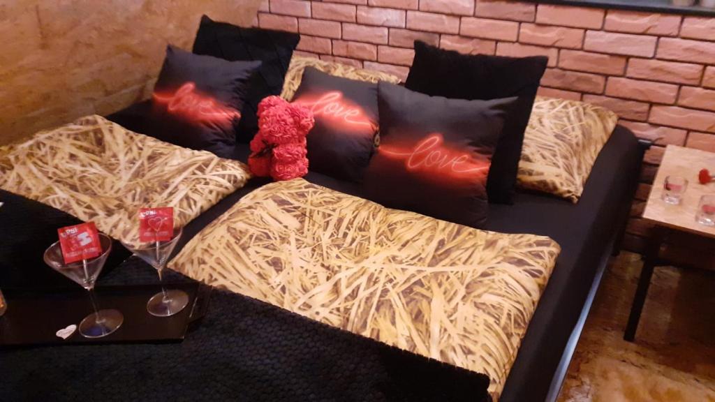 a couch with pillows and two glasses of wine at Zaciszny Zakątek Zawoja in Zawoja