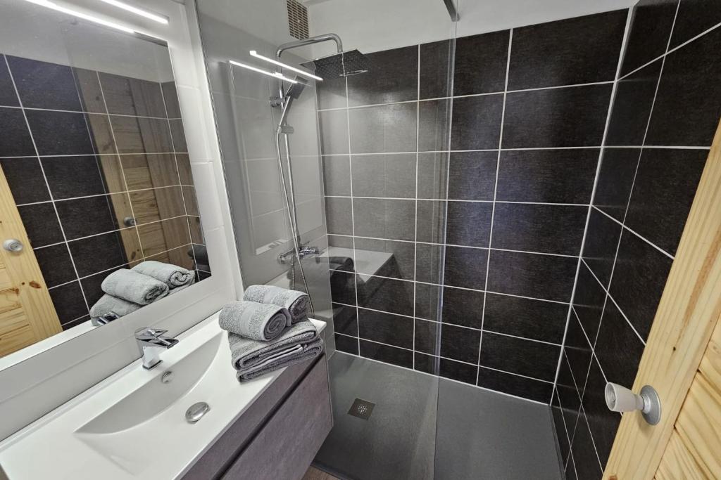 La salle de bains est pourvue d&#39;un lavabo et d&#39;une douche avec un miroir. dans l&#39;établissement Appartement Le Golfeur, à Saint-François